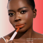 A Black model wearing Oplenza Hydrating Dewy Lip Balm in 05 Peachie Berry with glossy dewy finish.