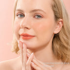 A Blonde Model wearing Oplenza Hydrating Dewy Lip Balm in Shade 05 Peachie with glossy dewy finish.