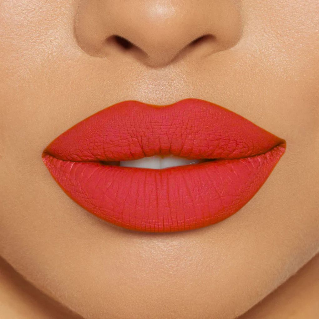 Close-up of model wearing oplenza Icon Matte Lipstick in shade 24 Coral Icon, best matte lipstick that stays on