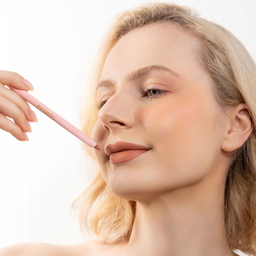An elegant woman wearing and showcasing the vegan, luxury and cruelty free oplenza Define & Refine Lip Liner in the color Bare Blush
