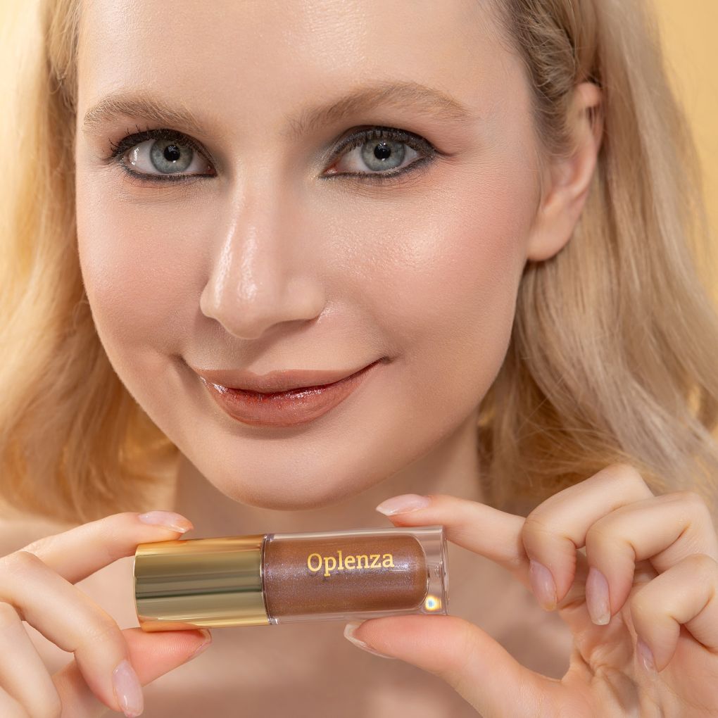 A woman wearing and showcasing the best cruelty-free, vegan, shiny and hydrating lip gloss in shade Bronze
