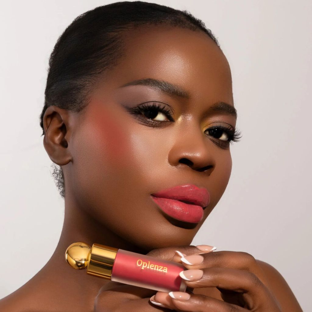 Woman wearing and presenting oplenza Velvet Whip cream blush in shade Burnt Kiss