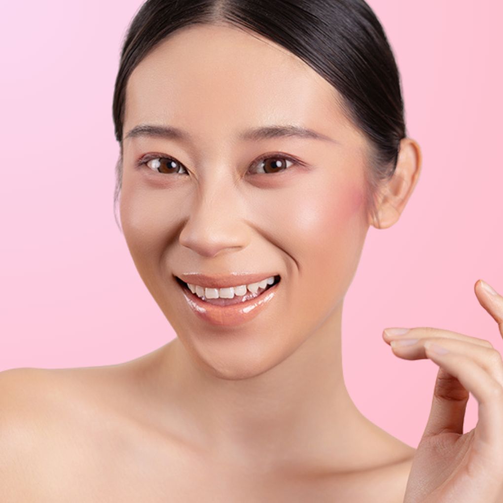 A woman wearing and showcasing the best cruelty-free, vegan, shiny and hydrating lip gloss in shade Dawn