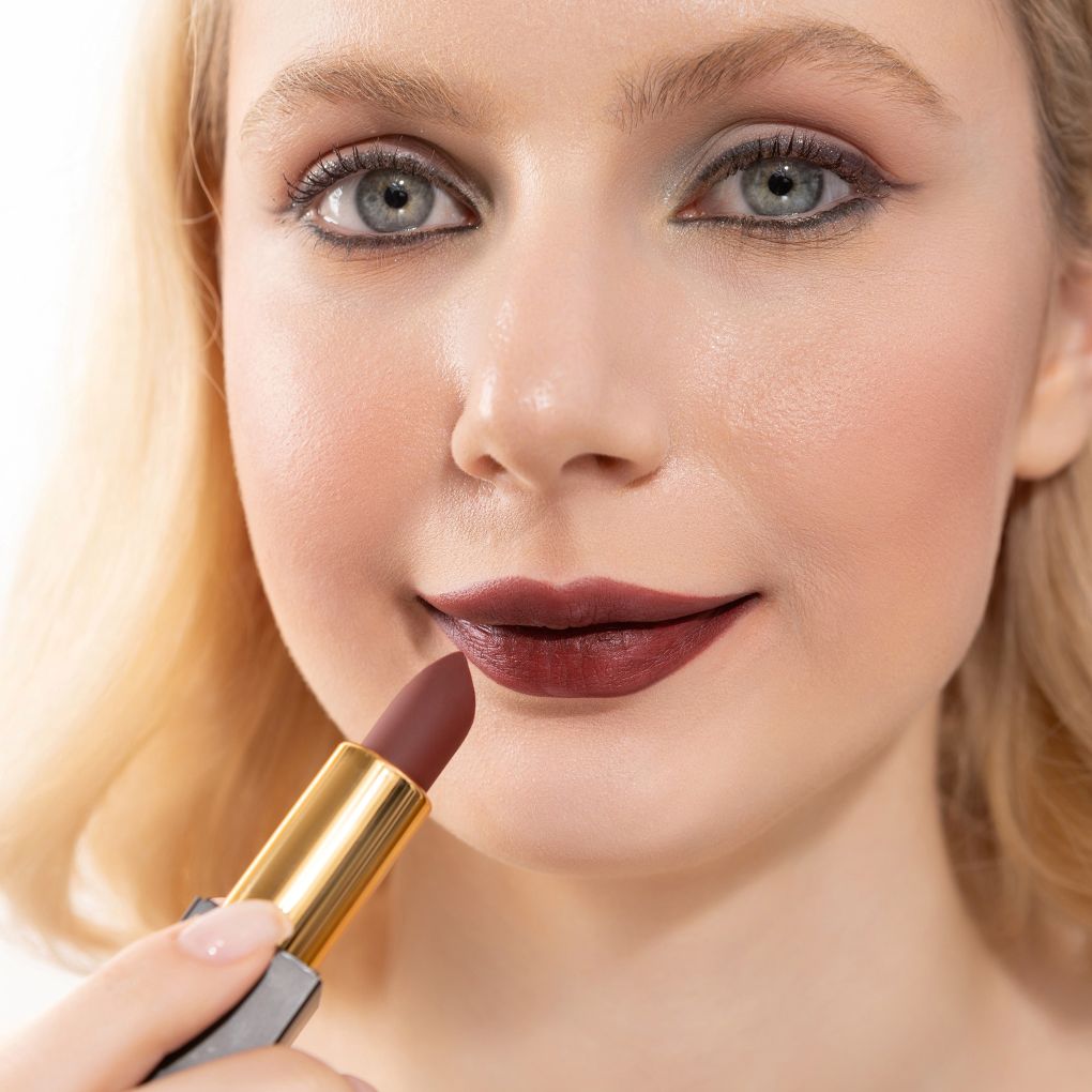 Woman applying and showcasing the effects of the best cruelty-free Oplenza Signature Matte Lipstick in shade Fearless
