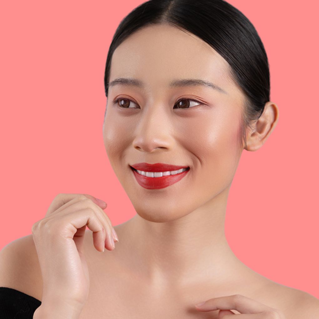Woman wearing and showcasing the effects of the best cruelty-free Oplenza Signature Matte Lipstick in shade Fiery