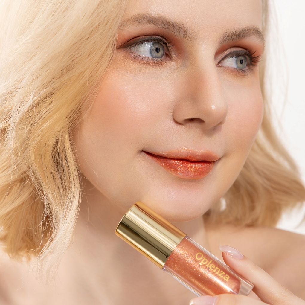 A woman wearing and showcasing the best cruelty-free, vegan, shiny and hydrating lip gloss in the Golden Hour shade