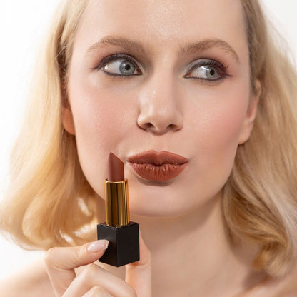 Woman applying and showcasing the effects of the best cruelty-free Oplenza Signature Matte Lipstick in shade Grounded