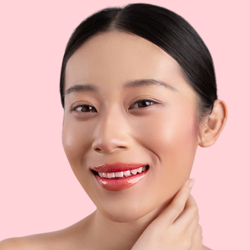 A woman wearing and showcasing the best cruelty-free, vegan, shiny and hydrating lip gloss in shade Luster