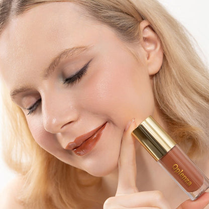 A woman wearing and showcasing the best cruelty-free, vegan, shiny and hydrating lip gloss in shade Maple