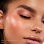 Woman wearing, showcasing on her face the Oplenza Luminous Pressed Powder Blush in shade Mood