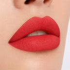 Close-up lip swatch of Oplenza Matte-to-Shine Lip Duo in Noir Red with a matte finish.