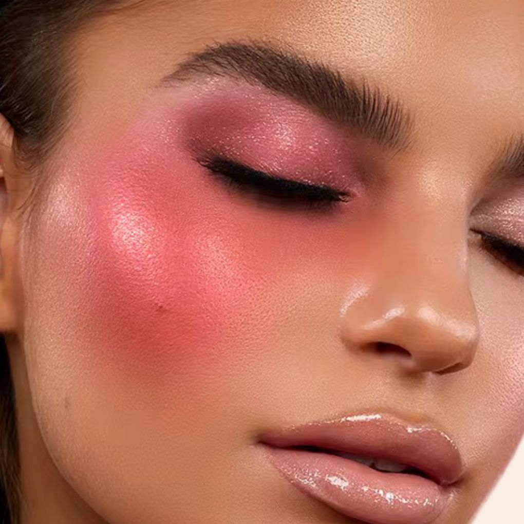 Woman wearing, showcasing on her face the Oplenza Luminous Pressed Powder Blush in shade Passion