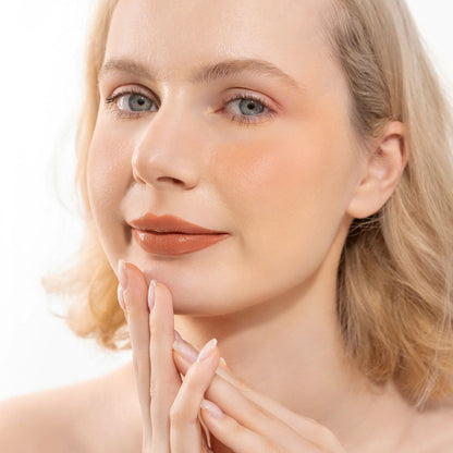 Woman wearing Oplenza Hydrating Dewy Lip Balm in shade Peachie, vegan hydrating lip care with natural glossy finish