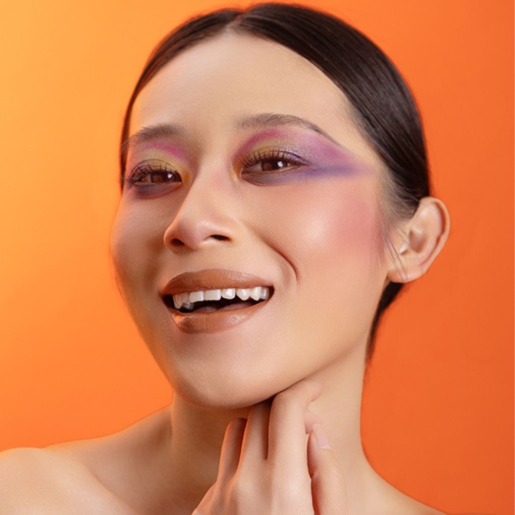 Model wearing and showcasing the bold color of the vegan, cruelty-free Oplenza matte liquid lipstick in the shade Poise