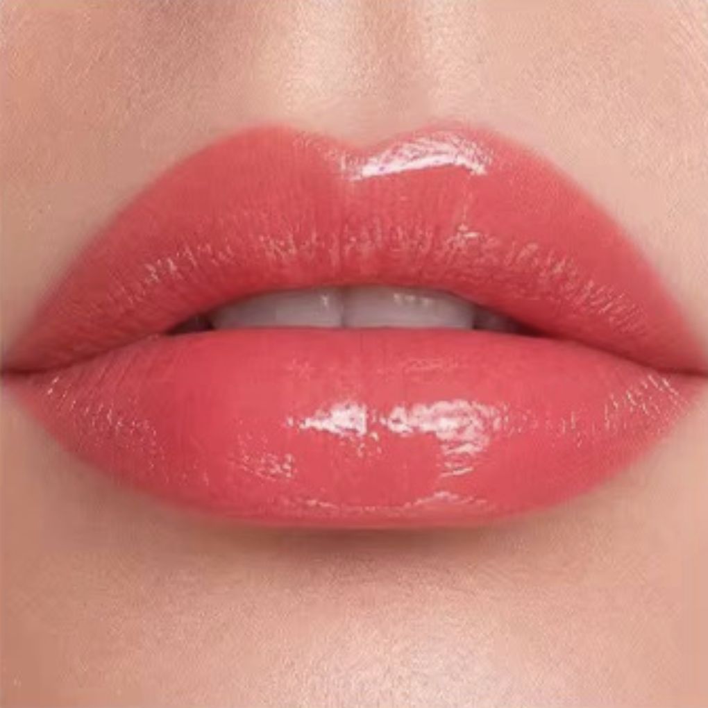 Close-up lip swatch of Oplenza Matte-to-Shine Lip Duo in Ripe Peach with a glossy finish.