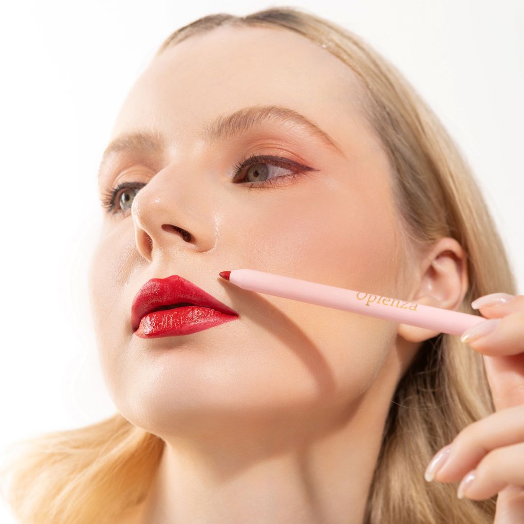 An elegant woman wearing and showcasing the vegan, luxury and cruelty free oplenza Define & Refine Lip Liner in the color Ruby Luxe