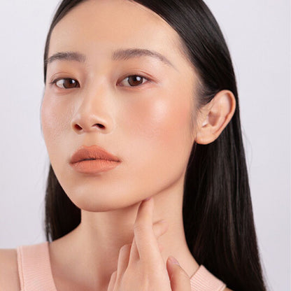 Model wearing and showcasing the bold color of the vegan, cruelty-free Oplenza matte liquid lipstick in the shade Solace