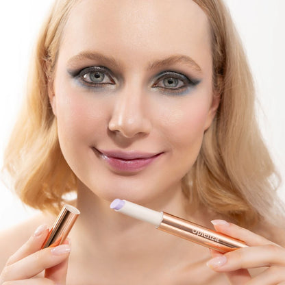 A woman wearing and presenting Oplenza's Hydrating Shimmer Glossy Lip Balm in shade Sugar