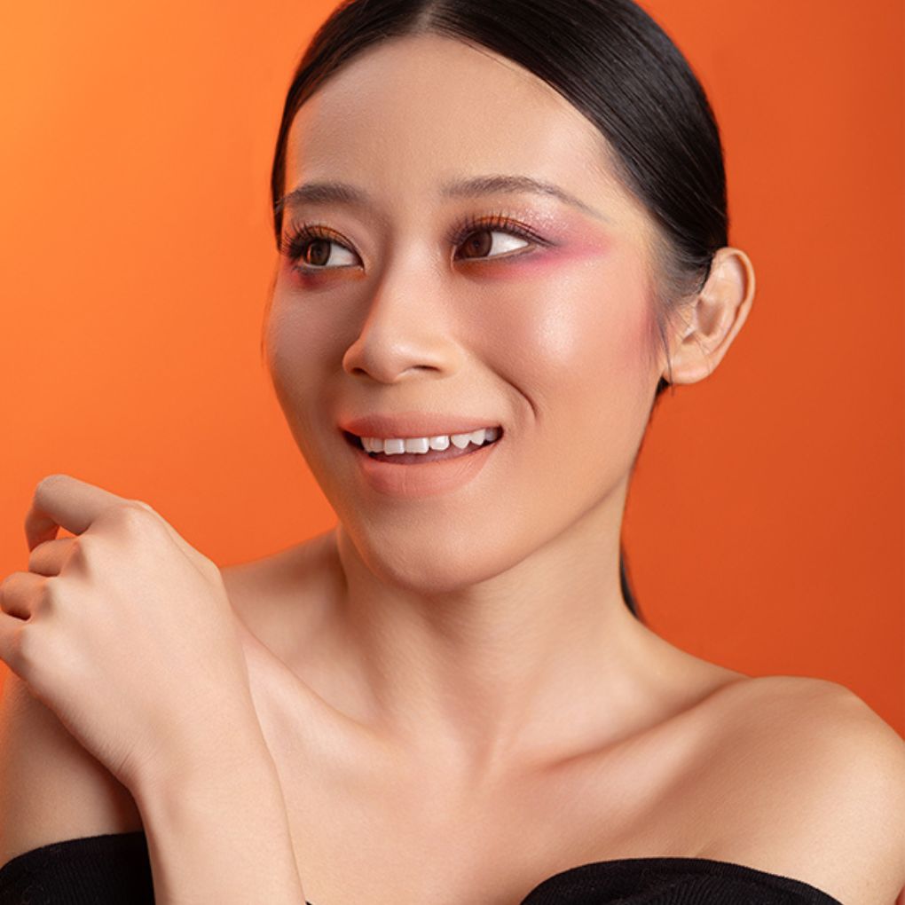 Model wearing and showcasing the bold color of the vegan, cruelty-free Oplenza matte liquid lipstick in the shade Whisper