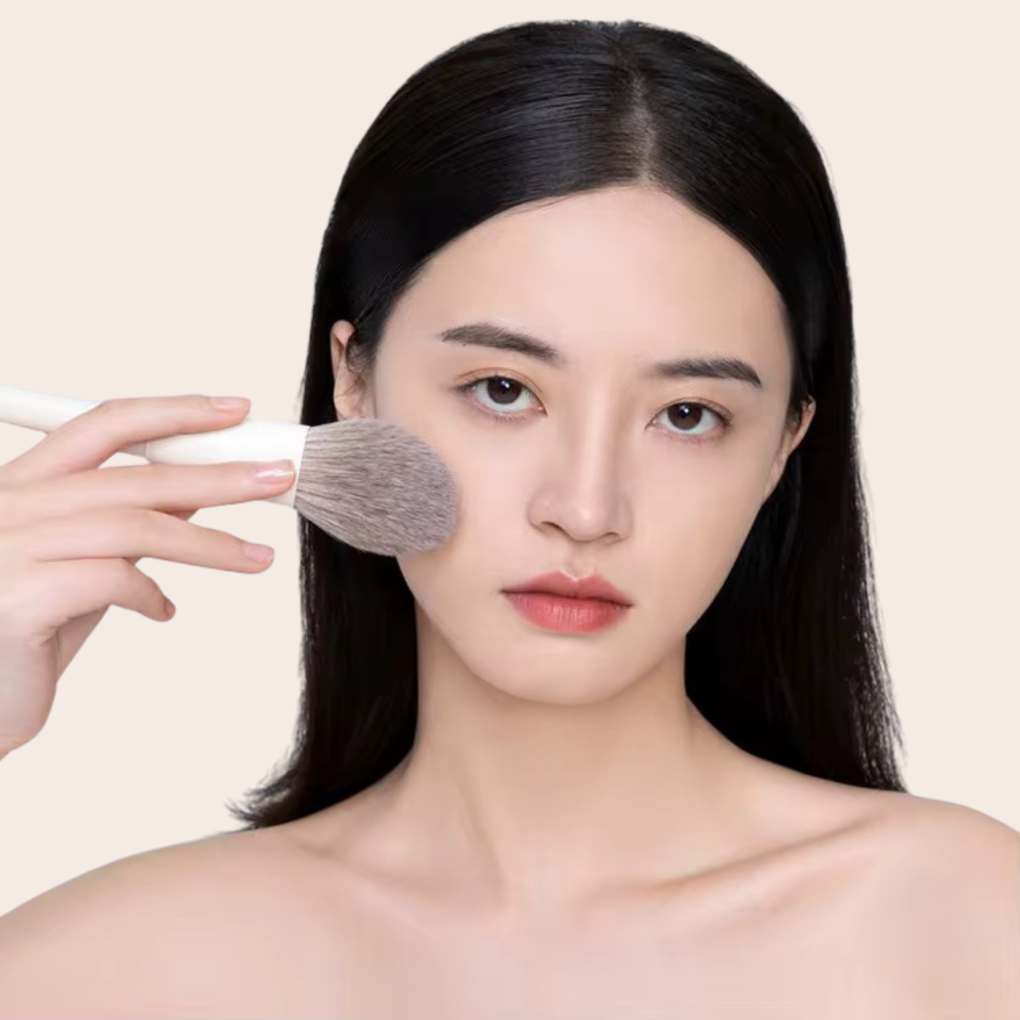 Woman using and showcasing oplenza foundation brush