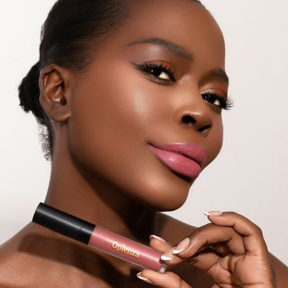 A Woman wearing and presenting the elegant Oplenza Signature Velvet Liquid Lipstick in the color Velour Blush